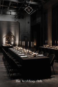 Modern minimalist wedding reception with black tablecloths, tall candles, and sleek monochrome wedding styling.