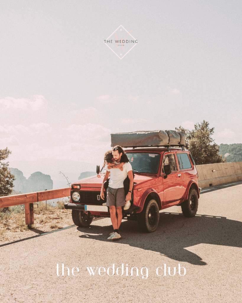 Couple on a road trip mini-moon with red vintage car – adventurous honeymoon idea for newlyweds exploring on a budget.