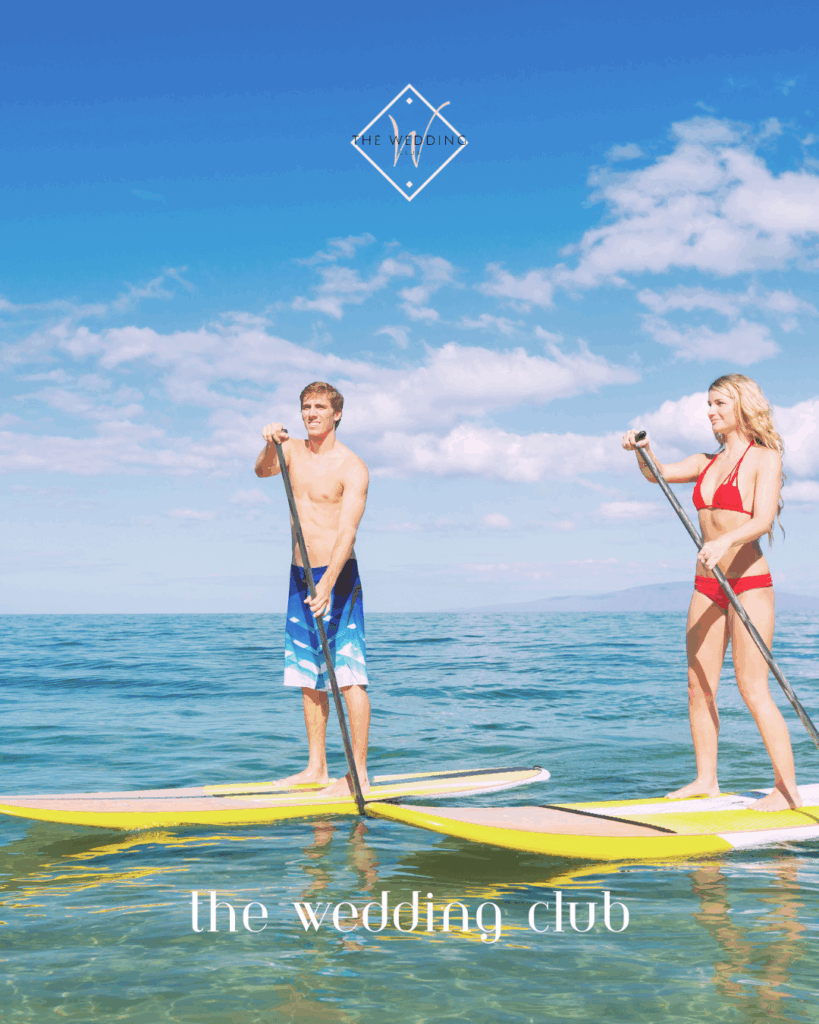 Active couple paddleboarding on turquoise ocean during a romantic mini-moon – affordable honeymoon idea for adventurous newlyweds.