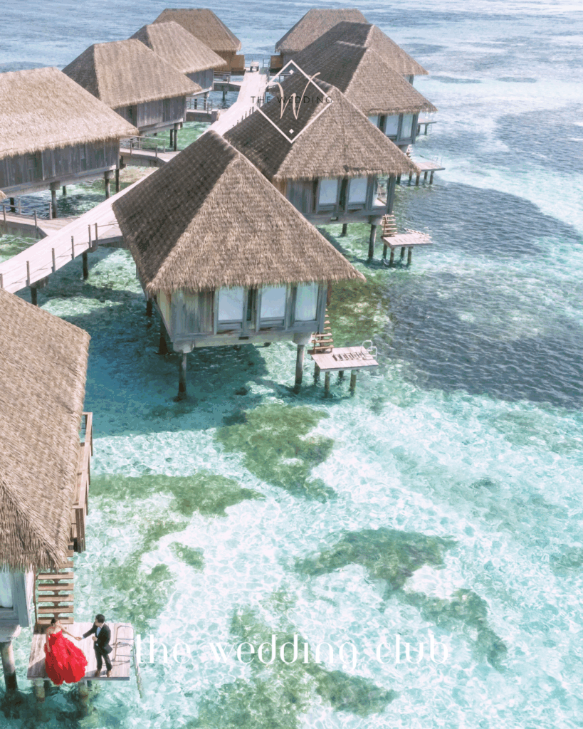 Luxury overwater villas perfect for a romantic mini-moon – honeymoon couples walking by crystal-clear waters in a tropical paradise.