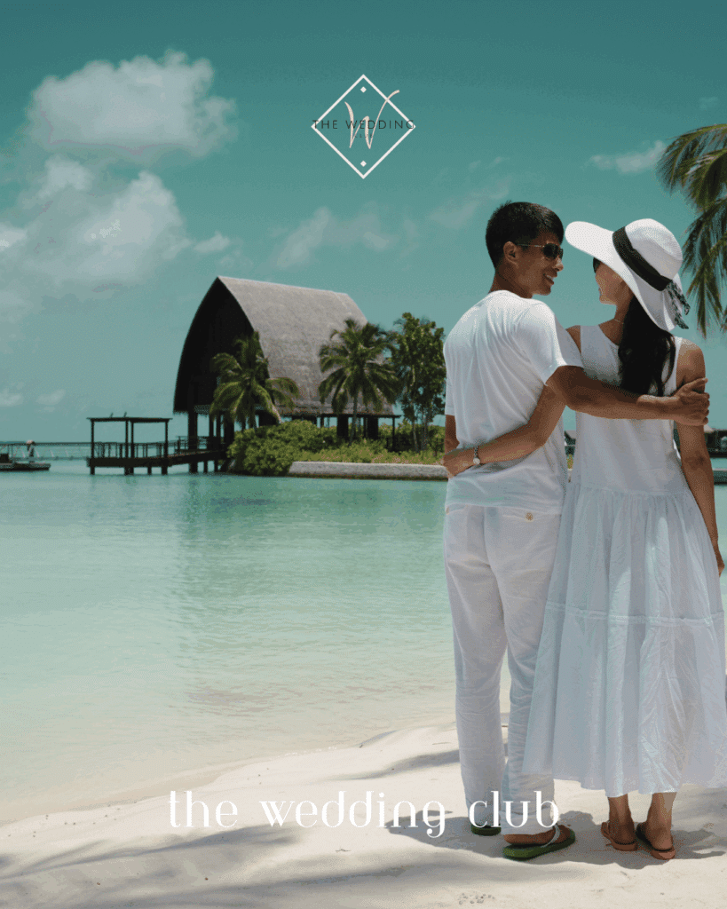 Couple embracing on a white sandy beach near a luxury resort – peaceful Trivago honeymoon hotel scene for a romantic mini-moon getaway.
