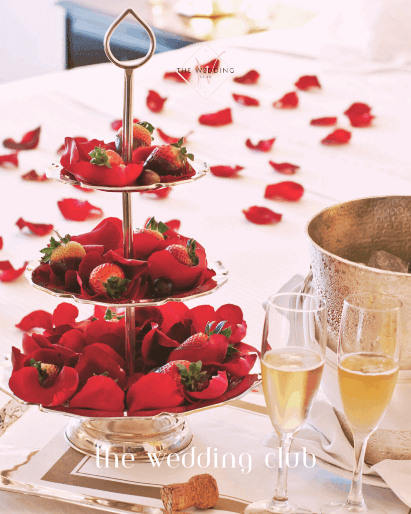 Mini-moon hotel room setup with champagne, strawberries, and rose petals – romantic honeymoon hotel scene.