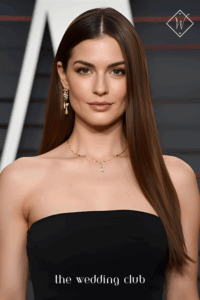 Sleek straight long hairstyle with middle part, black minimalist gown, gold jewelry, chic black-tie wedding background