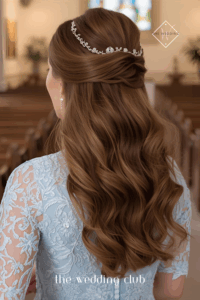 Smooth half-up style with volume at crown, light blue lace sleeve dress, clutch purse, chapel aisle background
